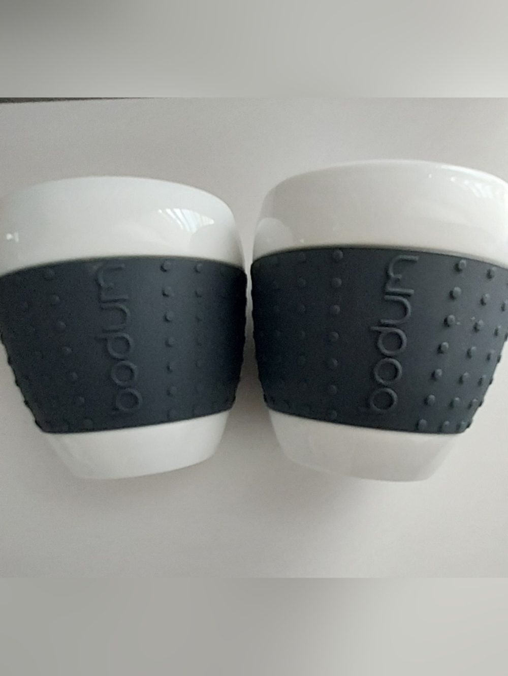 BODUM Pavina White Porcelain Cup Black Dotted Silicone Grip Two Modern Sleek